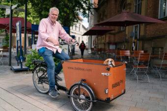 Jupp Westfeld auf seinem Lastenrad und seinem Hund in der Box.